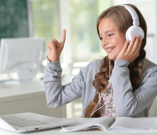 ubiMaster: Lernen leicht gemacht – Kostenlos mit MEINKonto SMART! Ein Mädchen mit Kopfhörern sitzt vor einem Laptop.