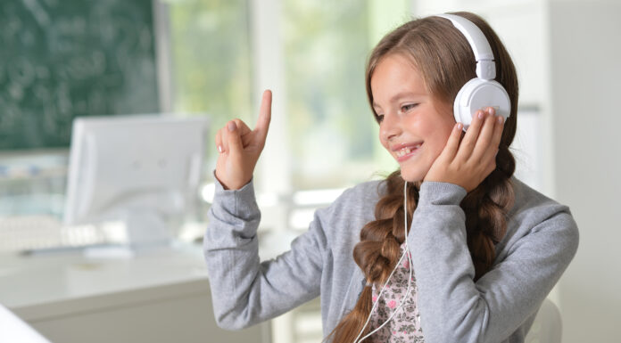 ubiMaster: Lernen leicht gemacht – Kostenlos mit MEINKonto SMART! Ein Mädchen mit Kopfhörern sitzt vor einem Laptop.