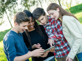 Erfolgreich in die Zukunft investieren – das Planspiel Börse der Förde Sparkasse Gruppe von Teeangern schaut gemeinsam auf ein Tablet