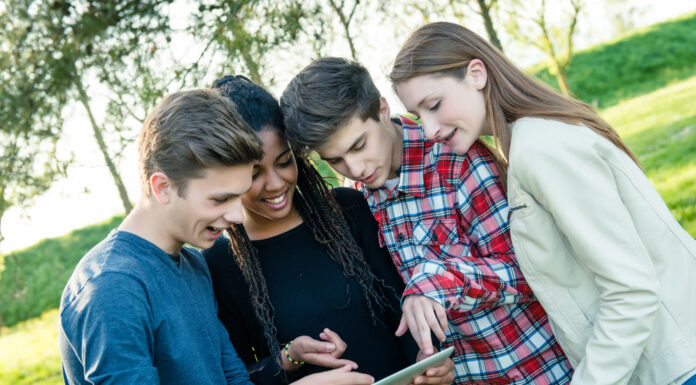 Erfolgreich in die Zukunft investieren – das Planspiel Börse der Förde Sparkasse Gruppe von Teeangern schaut gemeinsam auf ein Tablet