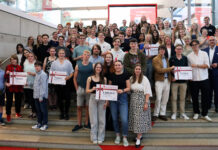 Netrace – Die Internetralley für Schüler:innen Gruppe von Schülerinnen und Schülern, die auf einer Treppe stehen und Plakate mit Gewinnsummen hochhalten.