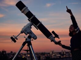 Chancen und Risiken im Börsenjahr 2025 Frau zeigt in den Himmel vor einem Teleskop