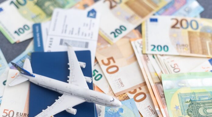 Flugpreise steigen 2025 Kleines Spielzeugflugzeuge steht auf mehreren Euro-Banknoten und einem Flugticket.