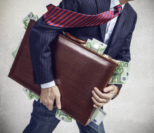 Wie groß ist 1 Million Euro? Ein Businessmann mit einem Aktenkoffer, aus dem 100-Euro-Scheine rausfallen.