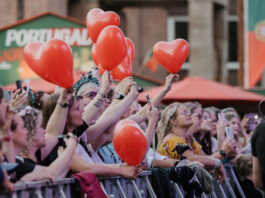 Kieler Woche: Weniger Zeit fürs Bezahlen, mehr Zeit fürs Feiern Menschen feiern mit roten Ballons in den Händen auf einem Konzert der Rathausbühne der Kieler Woche