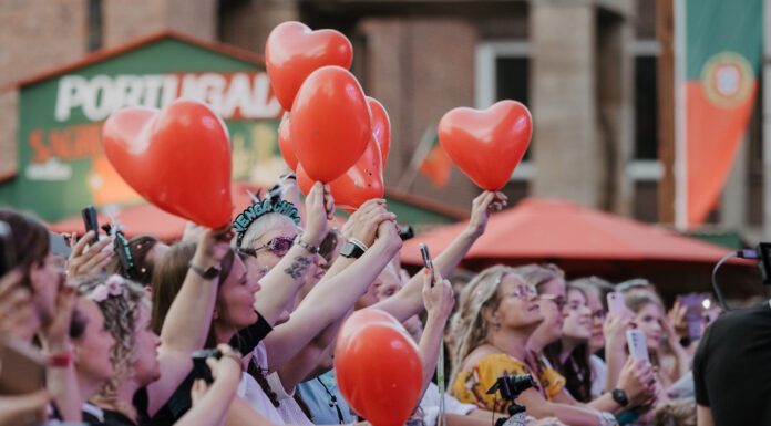Kieler Woche: Weniger Zeit fürs Bezahlen, mehr Zeit fürs Feiern Menschen feiern mit roten Ballons in den Händen auf einem Konzert der Rathausbühne der Kieler Woche