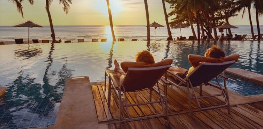 Altersvorsorge 2025: So sichern Sie sich finanziell ab Paar entspannt sich am Strand unter Palmen