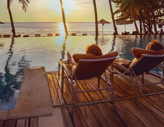 Altersvorsorge 2025: So sichern Sie sich finanziell ab Paar entspannt sich am Strand unter Palmen