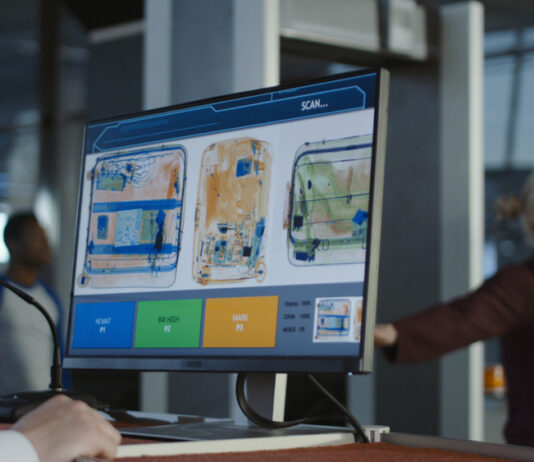 Zollbestimmungen – Was darf ich aus dem Urlaub mitbringen? Anonymer Mann am Checkpoint am Flughafen, der Gepäck auf dem Bildschirm mit Röntgenaufnahme erkundet.