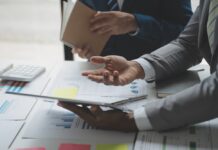 Unternehmensbewertung: So ermitteln Sie den Wert Ihres Unternehmens Zwei Männer analysieren Geschäftsfinanzberichte