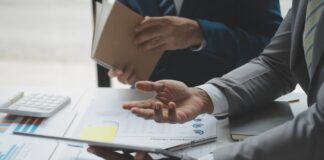 Unternehmensbewertung: So ermitteln Sie den Wert Ihres Unternehmens Zwei Männer analysieren Geschäftsfinanzberichte