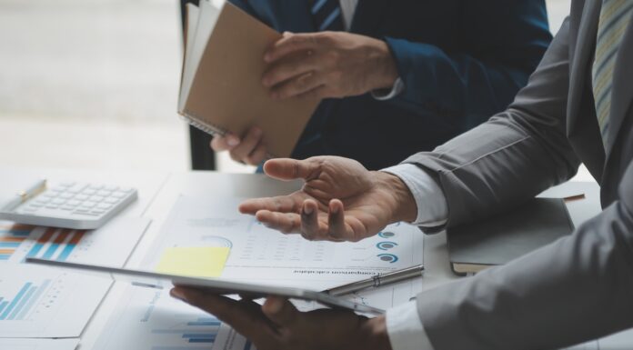 Unternehmensbewertung: So ermitteln Sie den Wert Ihres Unternehmens Zwei Männer analysieren Geschäftsfinanzberichte