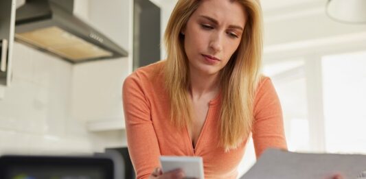 10 Tipps, wie Sie Heizkosten sparen Frau prüft Heizkostenabrechnung