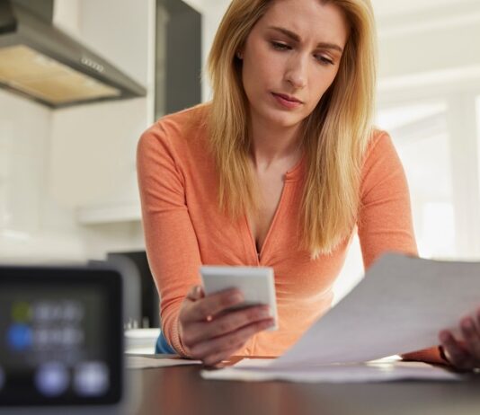10 Tipps, wie Sie Heizkosten sparen Frau prüft Heizkostenabrechnung