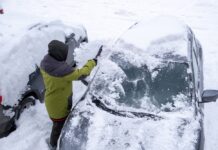 Schneechaos in Norddeutschland: Rechte, Pflichten und praktische Tipps Eine Person entfernt Schnee von der Frontscheibe eines Autos