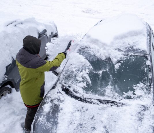 Schneechaos in Norddeutschland: Rechte, Pflichten und praktische Tipps Eine Person entfernt Schnee von der Frontscheibe eines Autos