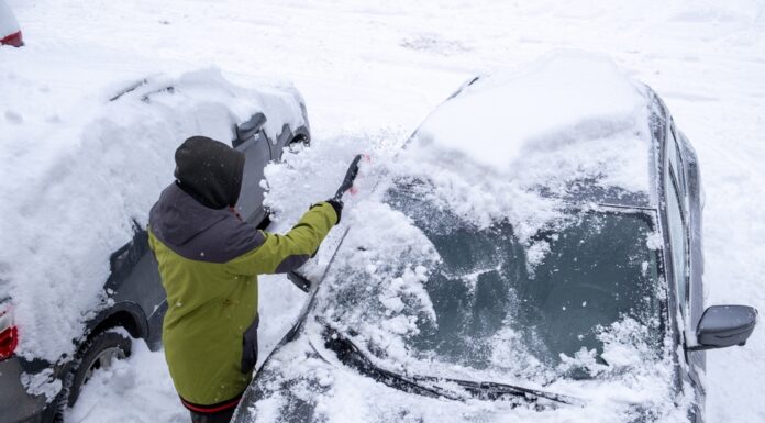 Schneechaos in Norddeutschland: Rechte, Pflichten und praktische Tipps Eine Person entfernt Schnee von der Frontscheibe eines Autos