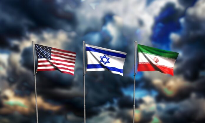 Die Flaggen von den USA, Isreal und Iran wehen vor einem dunklen, wolkenverhangenen Himmel.