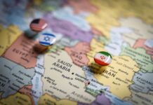 Iran-Krieg und Wirtschaft: Welche Auswirkungen der Konflikt auf den deutschen Mittelstand haben kann Politische Karte des Nahen Ostens mit Flaggennadeln der USA, Israels und des Iran an wichtigen geografischen Orten, die internationale Beziehungen und geopolitisches Bündniskonzept und Krieg im Nahen Osten repräsentieren.