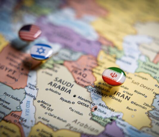 Iran-Krieg und Wirtschaft: Welche Auswirkungen der Konflikt auf den deutschen Mittelstand haben kann Politische Karte des Nahen Ostens mit Flaggennadeln der USA, Israels und des Iran an wichtigen geografischen Orten, die internationale Beziehungen und geopolitisches Bündniskonzept und Krieg im Nahen Osten repräsentieren.
