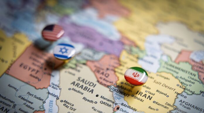 Iran-Krieg und Wirtschaft: Welche Auswirkungen der Konflikt auf den deutschen Mittelstand haben kann Politische Karte des Nahen Ostens mit Flaggennadeln der USA, Israels und des Iran an wichtigen geografischen Orten, die internationale Beziehungen und geopolitisches Bündniskonzept und Krieg im Nahen Osten repräsentieren.