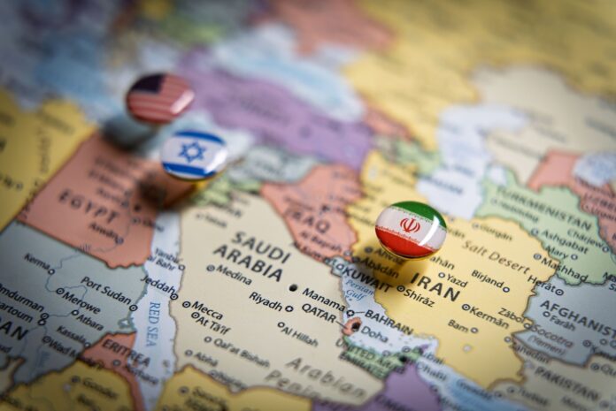 Politische Karte des Nahen Ostens mit Flaggennadeln der USA, Israels und des Iran an wichtigen geografischen Orten, die internationale Beziehungen und geopolitisches Bündniskonzept und Krieg im Nahen Osten repräsentieren.