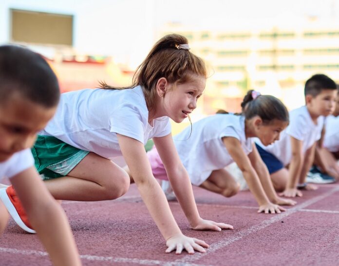 Young,Children,Having,Athletic,Exercise,Class,Running,On,The,Track, Kind am Startblock