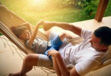 Anschlussfinanzierung: Strategien für das Ende Ihrer Zinsbindung Vater und Sohn in Hängematte klatschen sich ab.