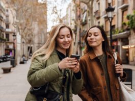 S‑Neo, S‑Broker, S‑Invest und Smartvermögen – Welche Wertpapier‑App passt zu wem? Junge Frauen schauen aufs Handy