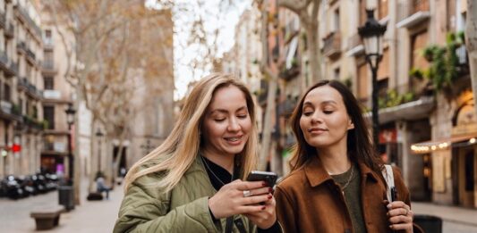 S‑Neo, S‑Broker, S‑Invest und Smartvermögen – Welche Wertpapier‑App passt zu wem? Junge Frauen schauen aufs Handy
