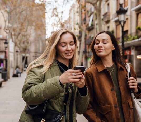 S‑Neo, S‑Broker, S‑Invest und Smartvermögen – Welche Wertpapier‑App passt zu wem? Junge Frauen schauen aufs Handy