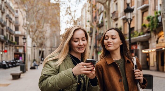 S‑Neo, S‑Broker, S‑Invest und Smartvermögen – Welche Wertpapier‑App passt zu wem? Junge Frauen schauen aufs Handy